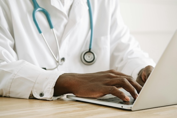 Doctor typing at a lap top