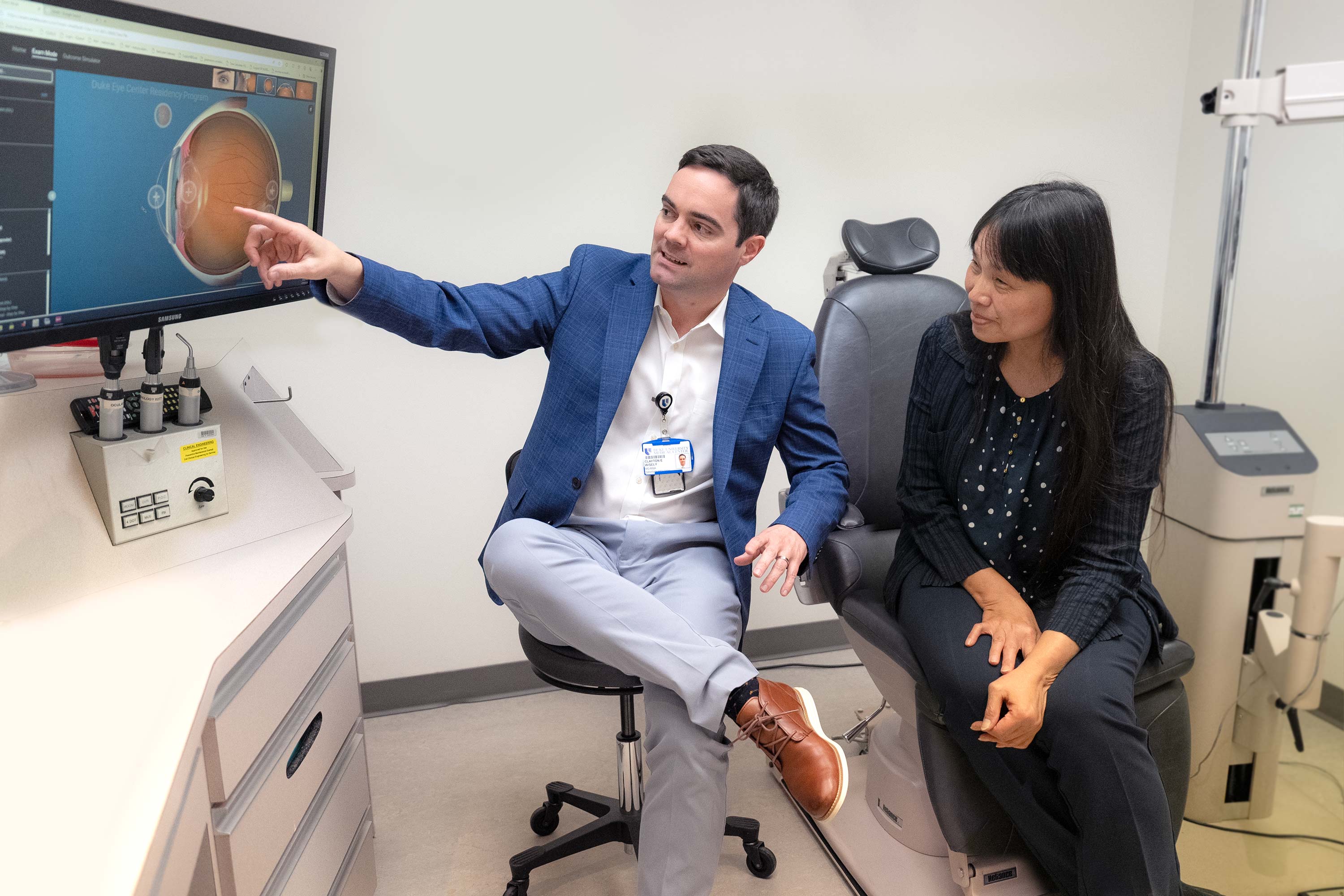 Two people looking into a digital screen in a medical facility