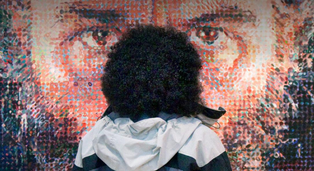 A child looking at a blown-up pixelated image of an angry man