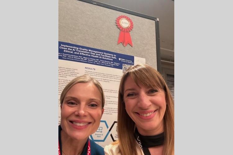 Nicoleta Economou and another woman in front of a research poster