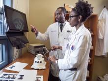 Two medical professionals using a simulator for surgical training practice.